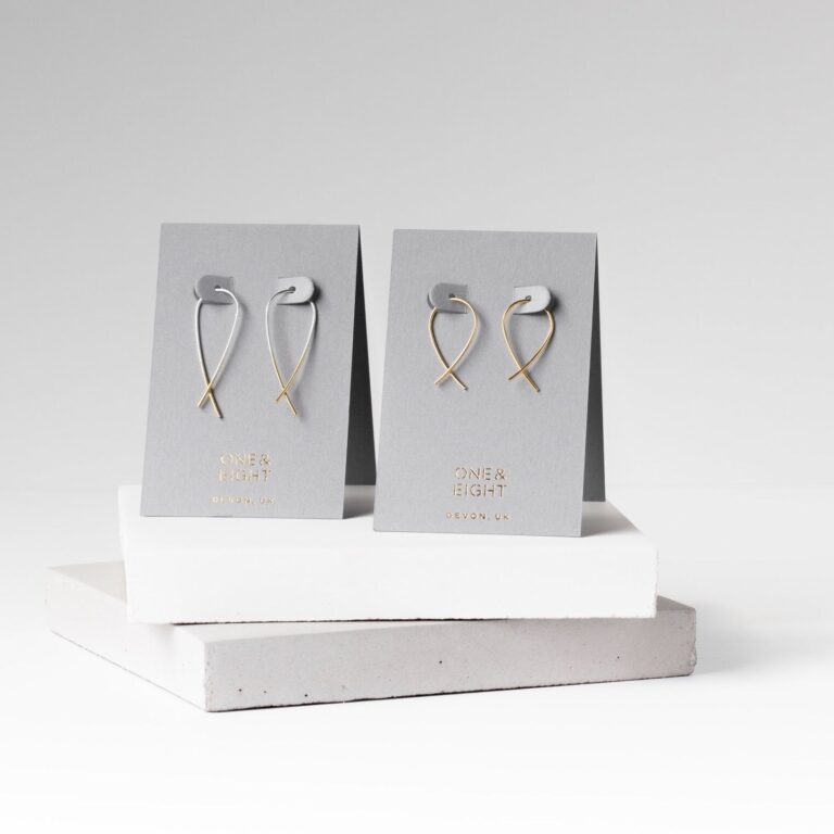 Gold Dipped Silver Crossover Earrings and Gold Crossover Mini Earrings on their card packaging