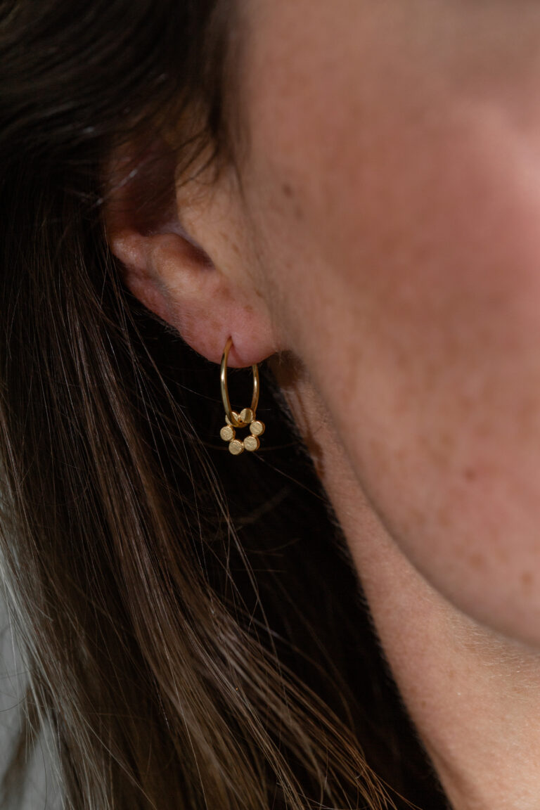Gold Holly Fern Flower Hoop Earrings being worn by model