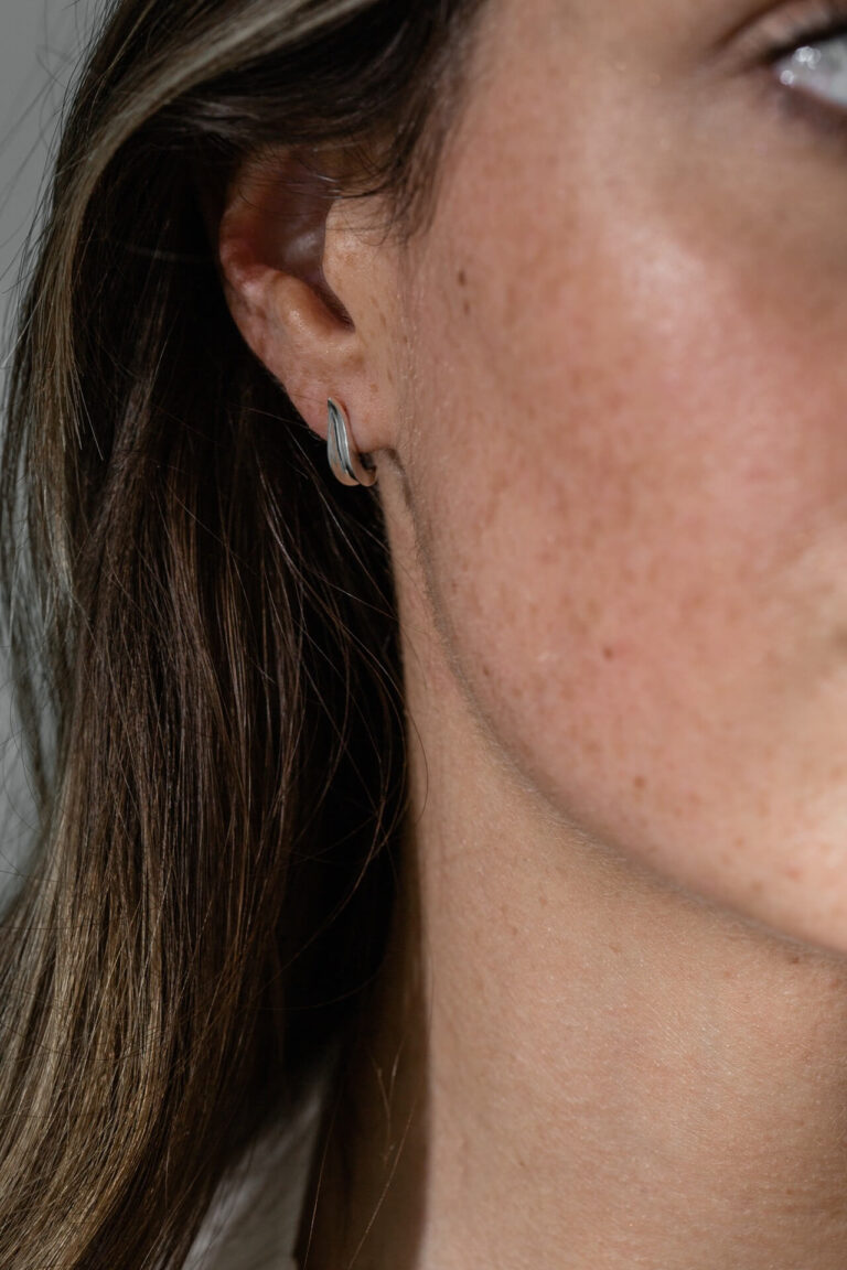 Close up of model's freckled face wearing elegant Mila Leaf Earrings