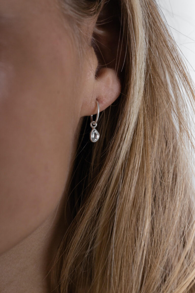 Close up of Silver Darcie Drop Earrings worn by model with blonde hair
