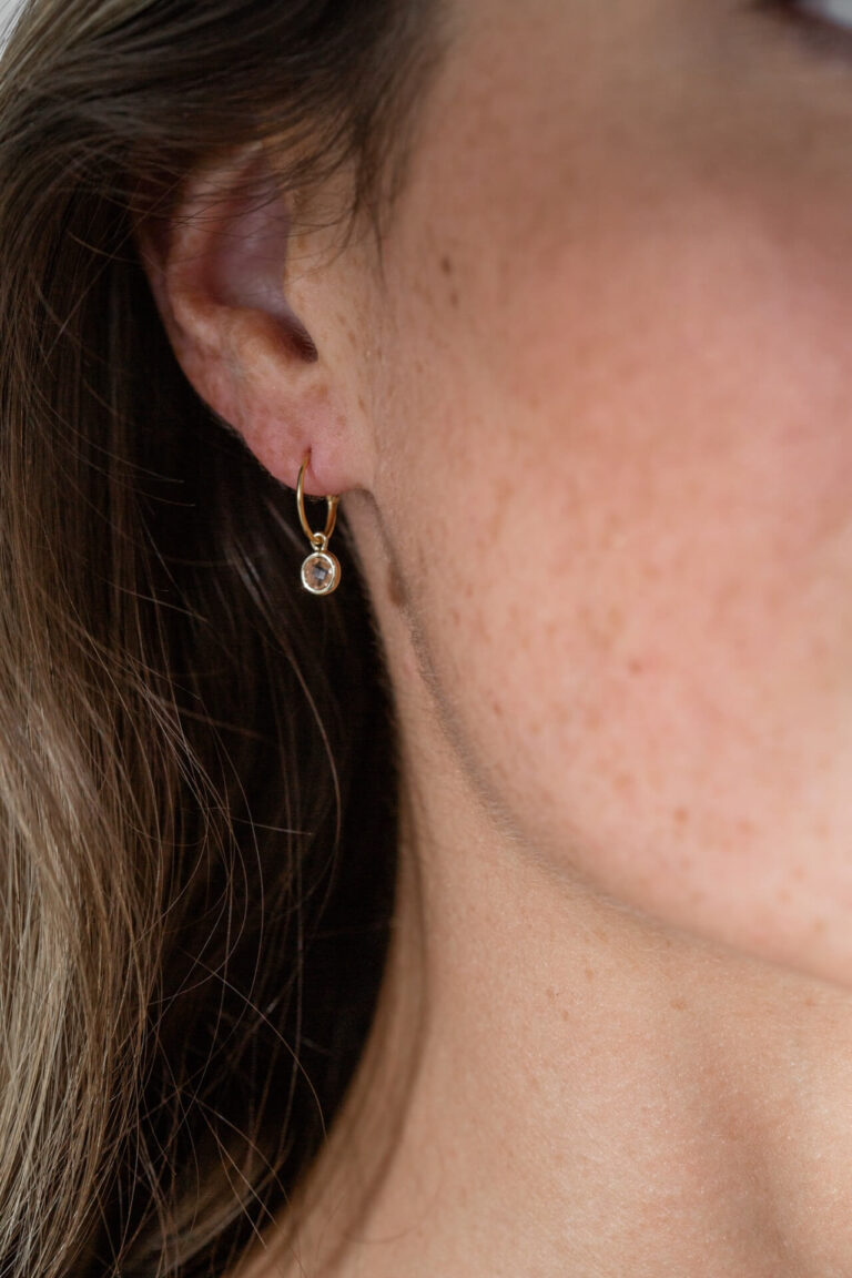 Close up of model with freckled skin wearing the Champagne Spirit Crystal Earring