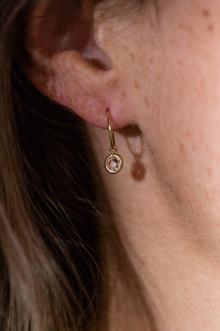 Close up of model with freckled skin wearing the Champagne Spirit Crystal Earring