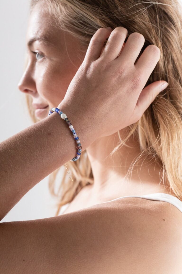 Model with blonde hair wearing Surf Rider Blue Bead Bracelet with blue denim shorts