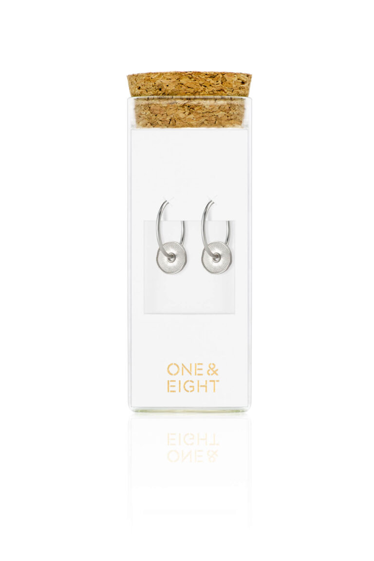 Silver Disc Sorrel Earrings on white card in a glass bottle with cork lid