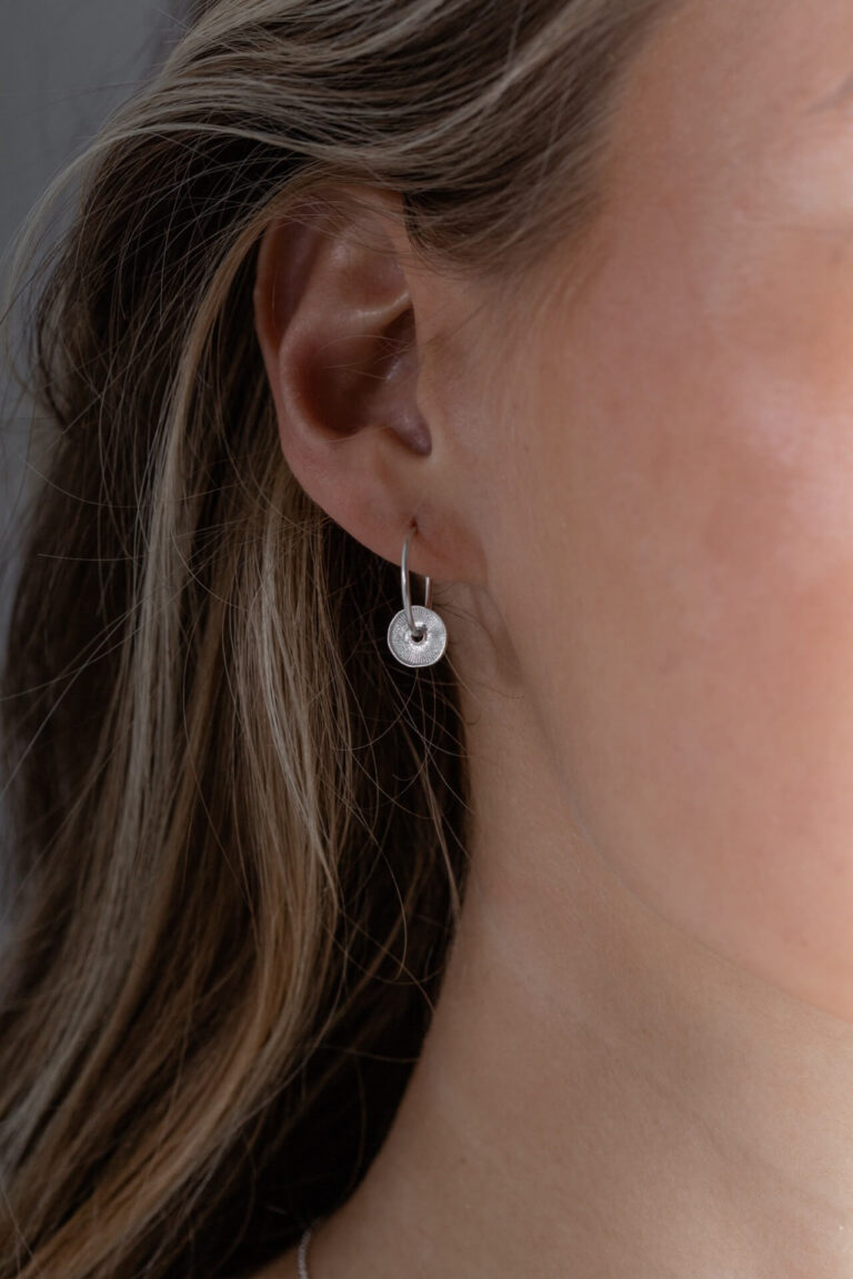 Close up of model with blonde hair wearing the Silver Disc Sorrel Earring