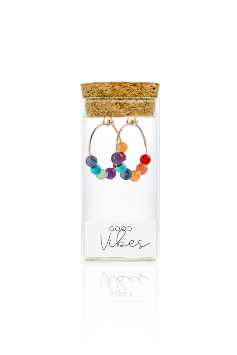 Multi-coloured beaded Chakra hoop earrings in a glass bottle with cork lid