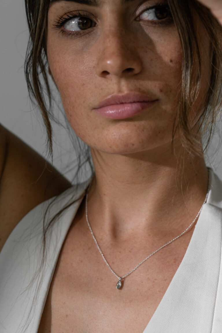 Model wears Recycled Silver Darcie Necklace and white v-neck top