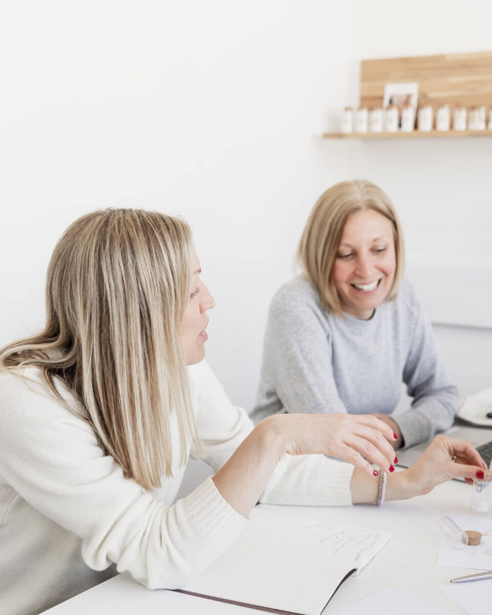 Two women in a meeting, smiling.