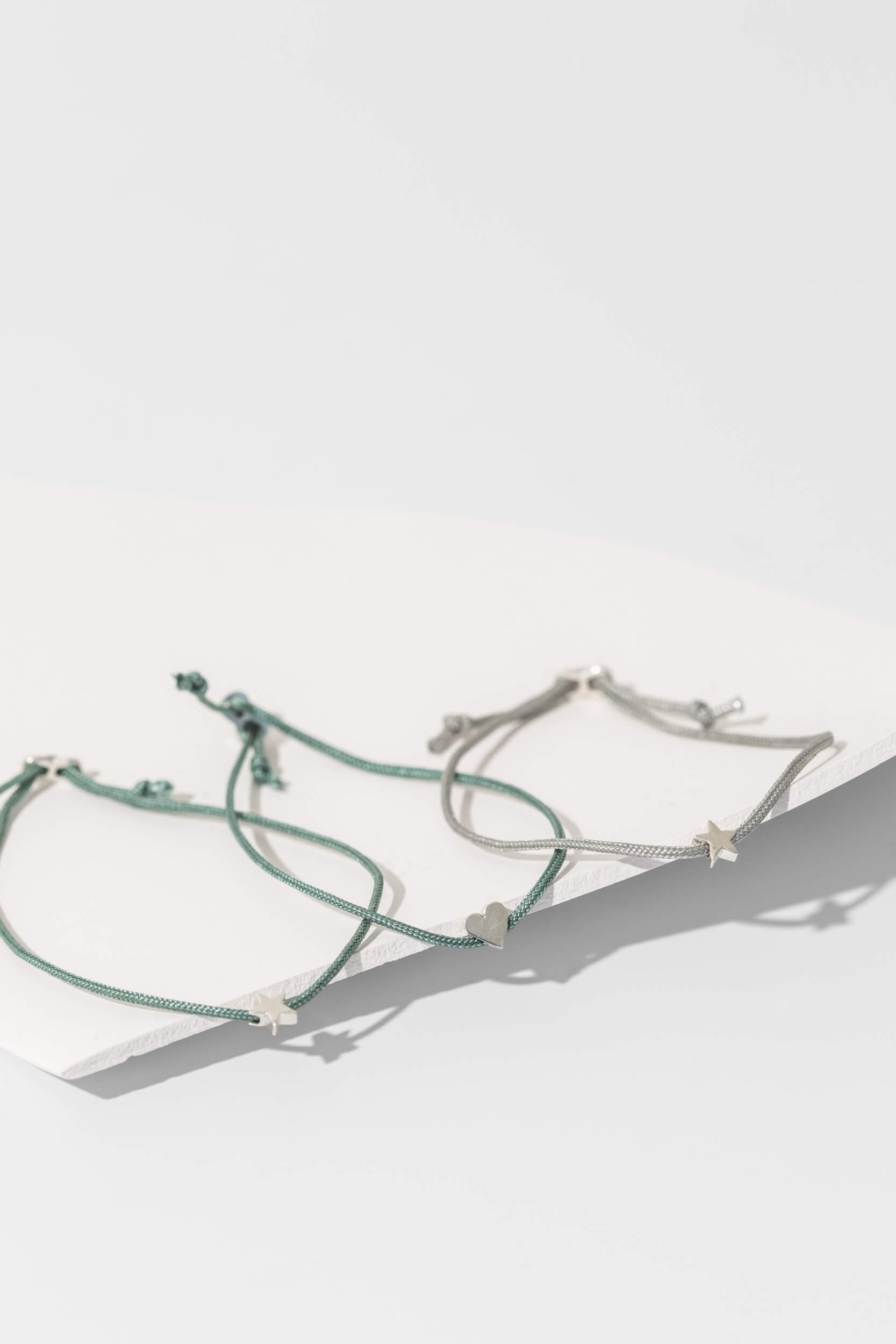 One-and-Eight-AW25-GV Silver Star on Sage Green Cord Bracelet Silver Heart on Sage Green Cord Bracelet Silver Star on Grey Cord Bracelet Lifestyle Web Size 3