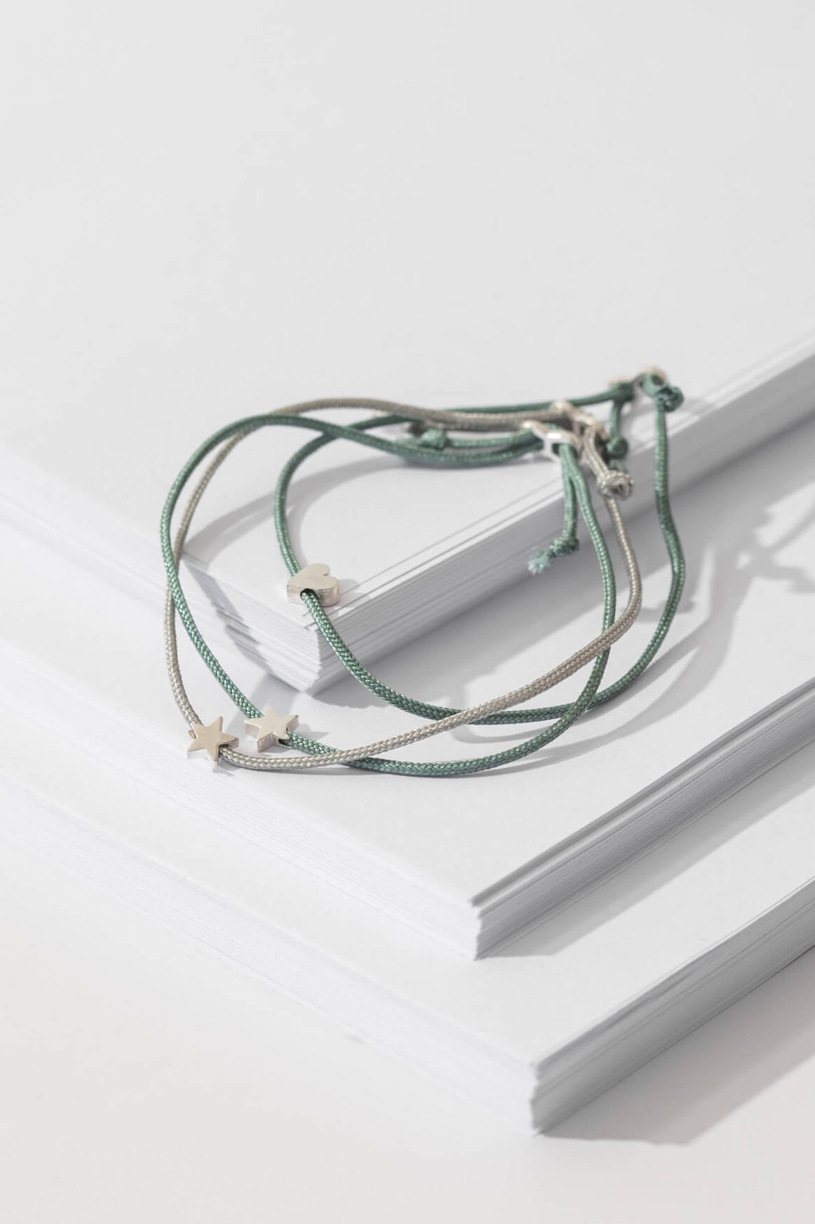 One-and-Eight-AW25-GV Silver Star on Sage Green Cord Bracelet Silver Heart on Sage Green Cord Bracelet Silver Star on Grey Cord Bracelet Lifestyle Web Size 4
