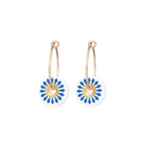 Small white porcelain disks with a blue flower motif and gold centre, threaded onto gold hoop earrings.